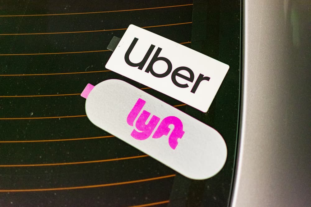 Uber and Lyft emblem on stickers on a rear window of a vehicle