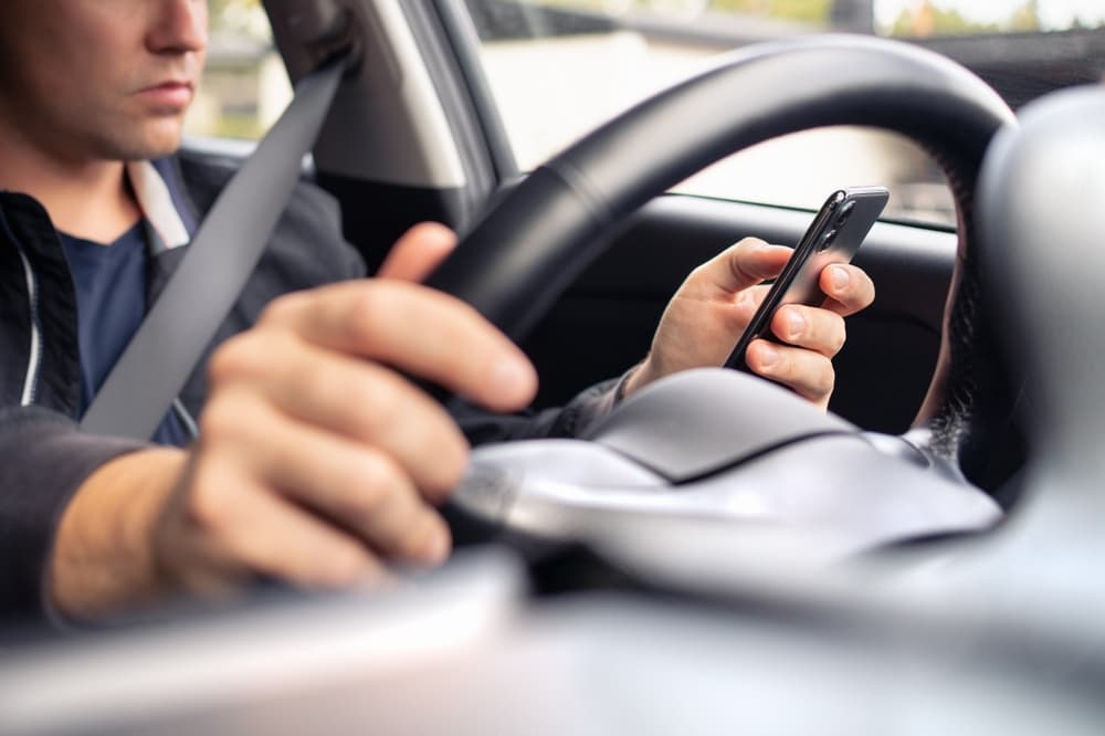 Texting and driving a rideshare car. Using mobile phone in traffic.