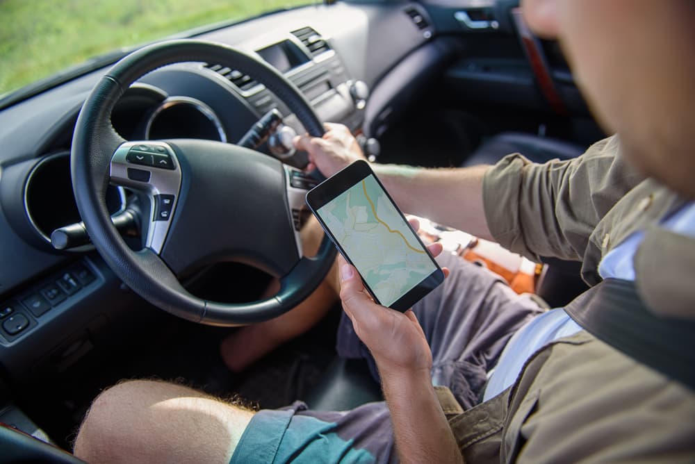 Male rideshare driver looking at map in smartphone
