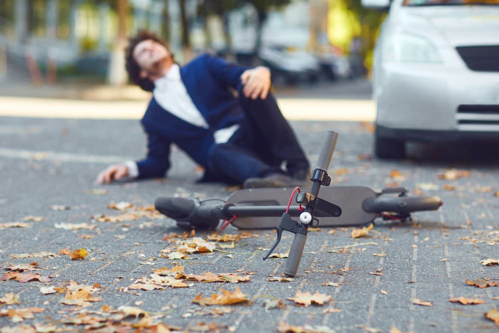 Accident with an electric scooter. A man fell from a scooter on a city street.