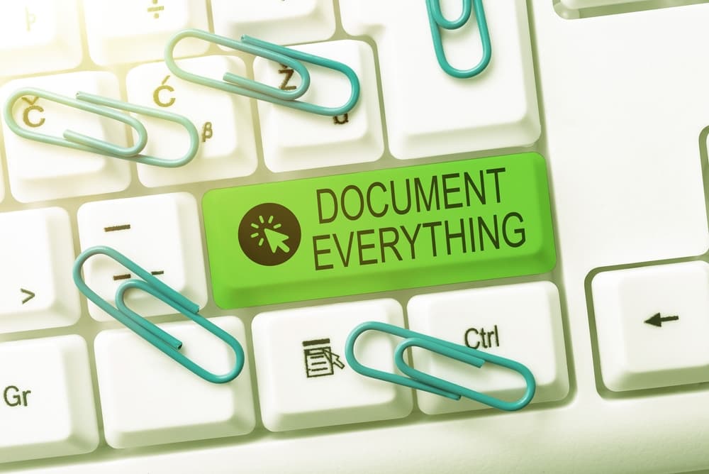 Conceptual image with the phrase "Document Everything" displayed, representing the importance of thorough documentation. A computer screen shows someone typing complex program codes or writing content for a new educational book.