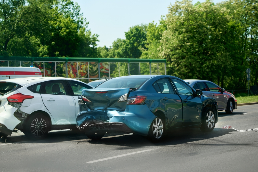 Scene of a multi-car collision on the road, showing several damaged vehicles involved in the accident, highlighting the severity of the traffic incident.