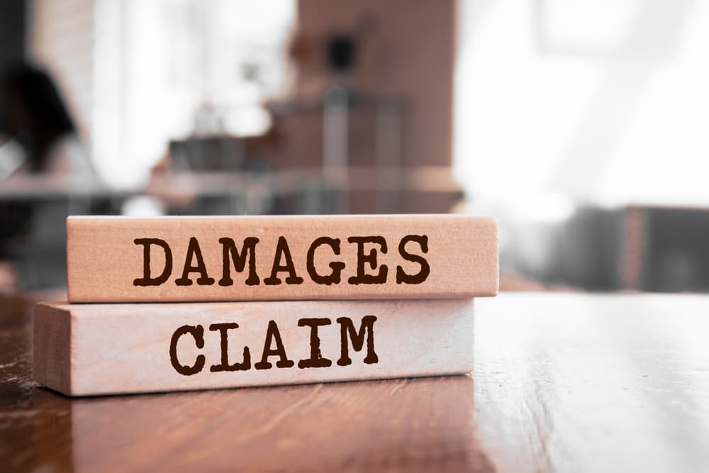 Damages & Claim written on wood blocks